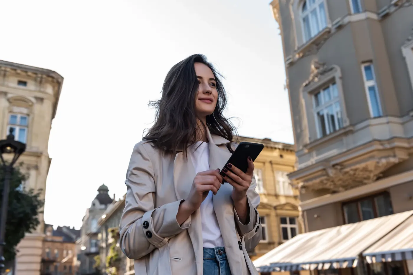 Woman using her smartphone in a city street, where paid online ads for less healthy food are now banned