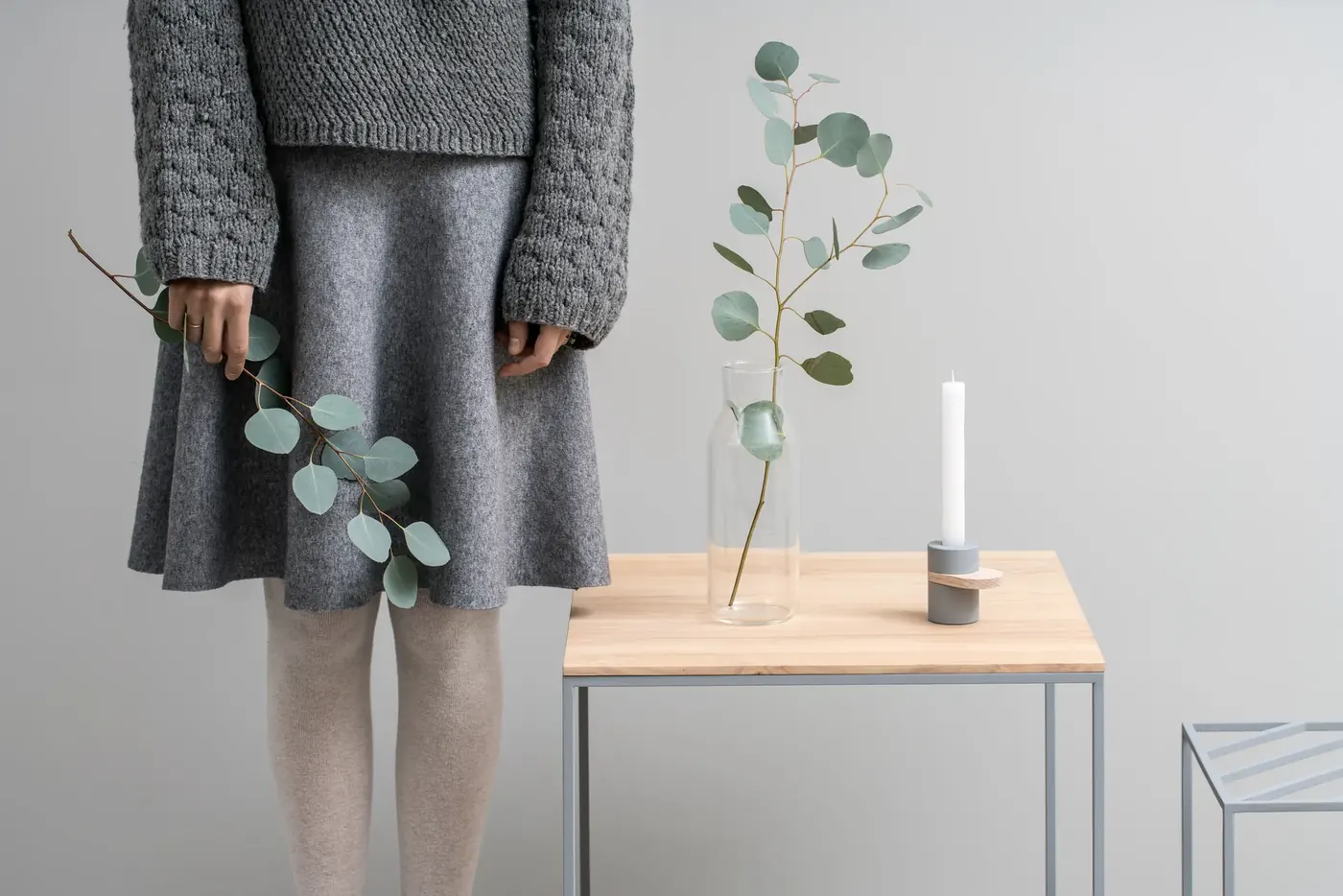 Woman holding eucalyptus in a minimal interior