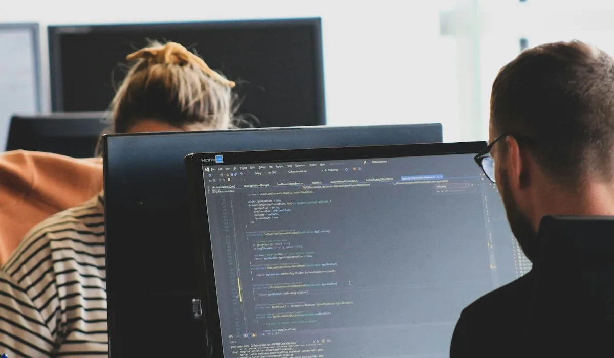 Developers coding side by side in a bright office, adding Voxly Vision ad compliance checks to a content pipeline