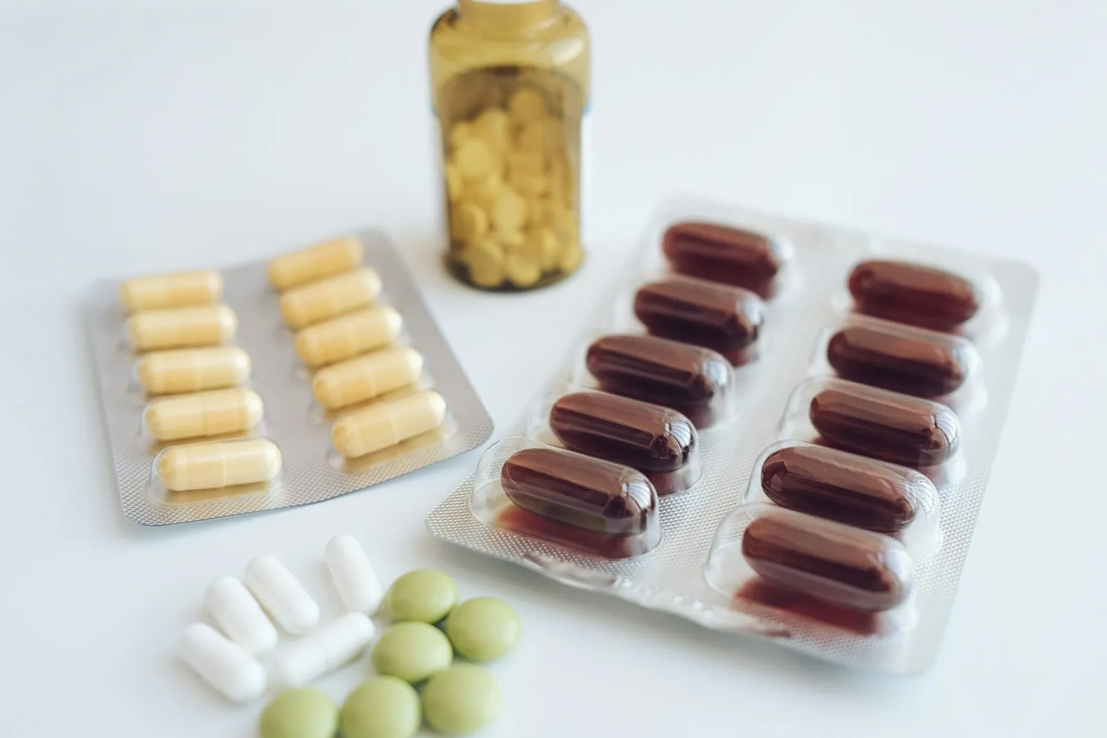 Assorted pills and capsules on a white surface, illustrating the line between health claims and medicinal claims in supplement advertising
