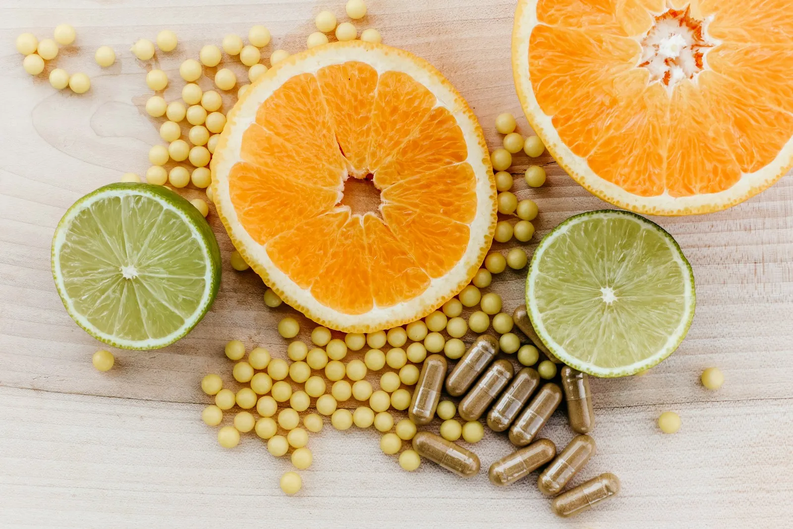 Citrus slices, supplement beads and capsules on a wooden table, illustrating health claims for supplements and the GB Nutrition and Health Claims Register